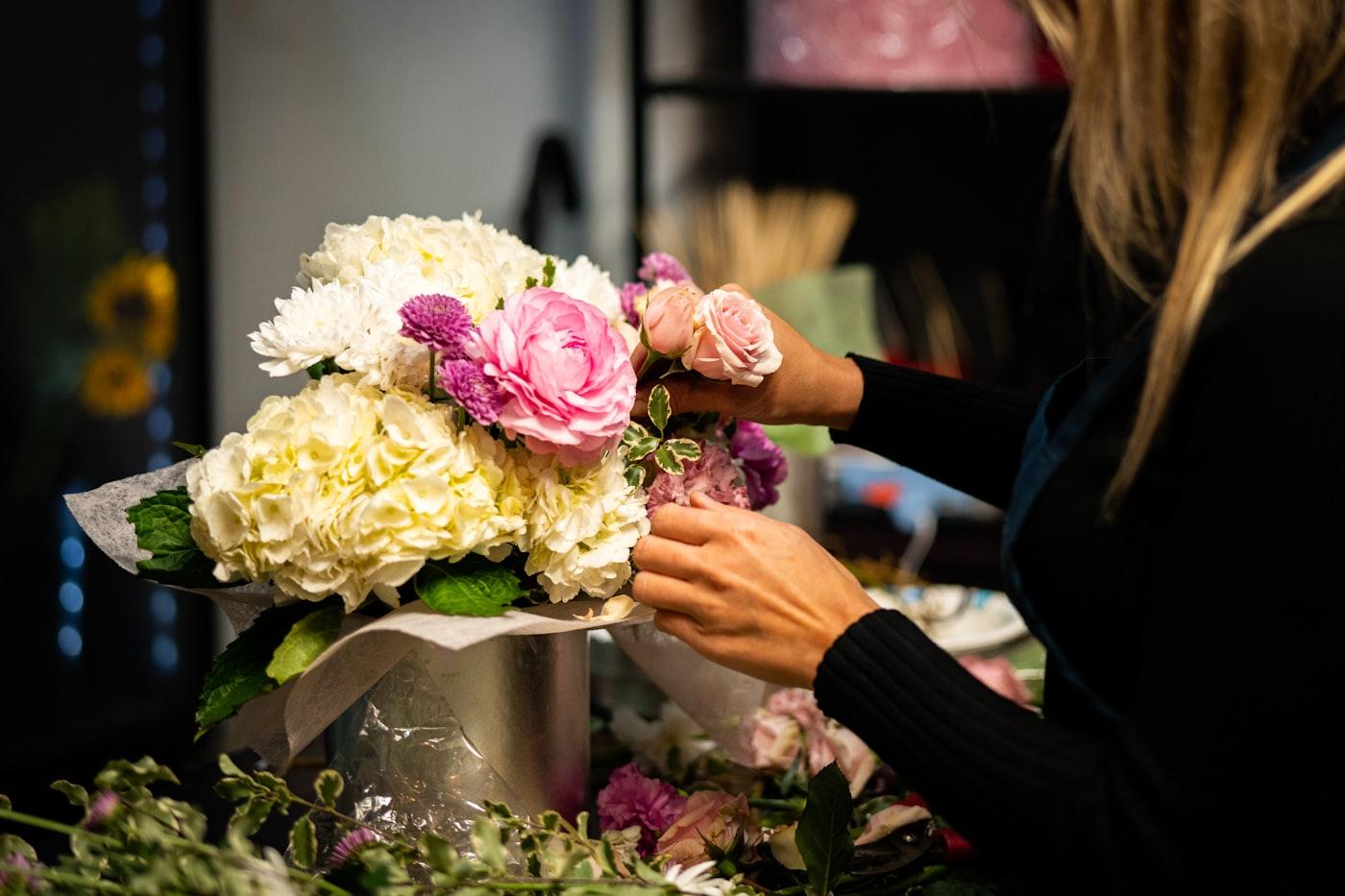 Une fleuriste compose un bouquet dans son atelier